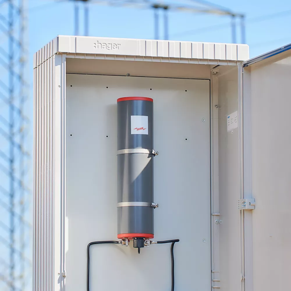 Open electrical cabinet with a grey cylindrical DEHN surge device mounted inside.